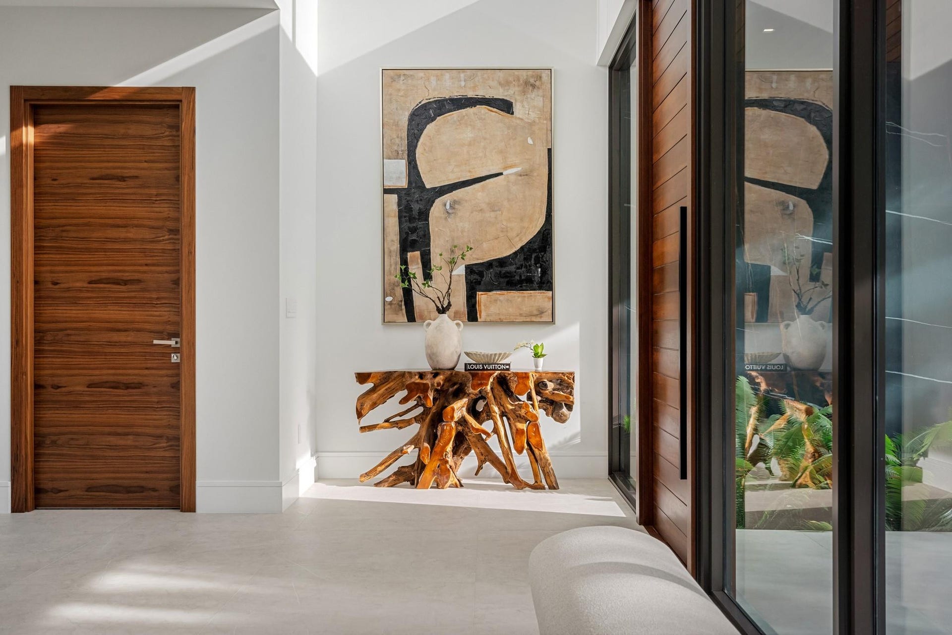 2000 Harbourview Drive, Fort Lauderdale, FL 33316 A refined entry vignette showcasing a rich wood front door, sleek glass panels, and curated modern artwork that sets an elegant first impression. Clean lines and warm textures create a welcoming yet sophisticated arrival experience.