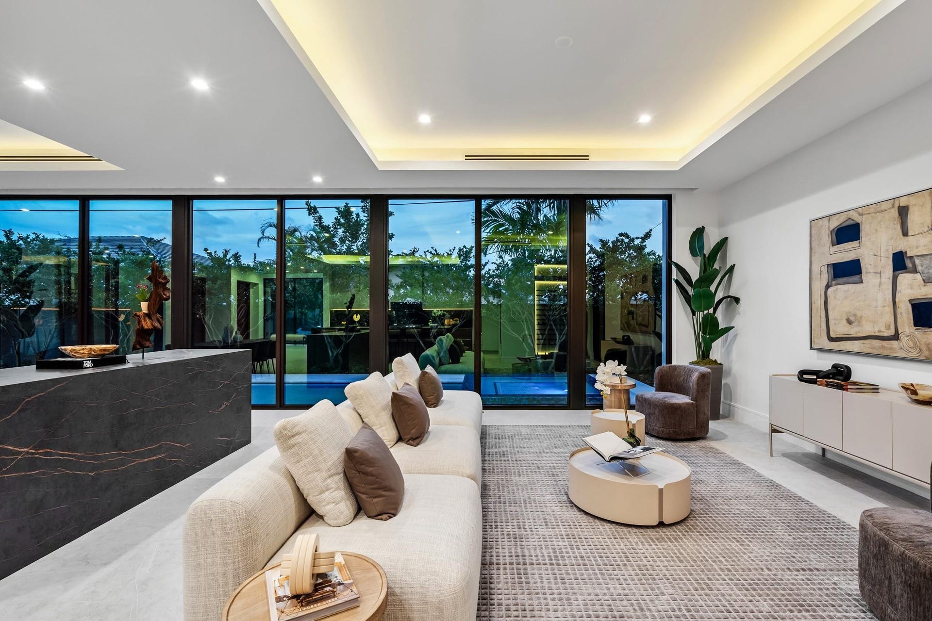 2000 Harbourview Drive, Fort Lauderdale, FL 33316 A stunning contemporary living room highlighted by sleek architectural lines, recessed ceiling lighting, and expansive walls of glass overlooking lush greenery. Sophisticated and serene, this open space seamlessly blends indoor elegance with effortless outdoor connection.
