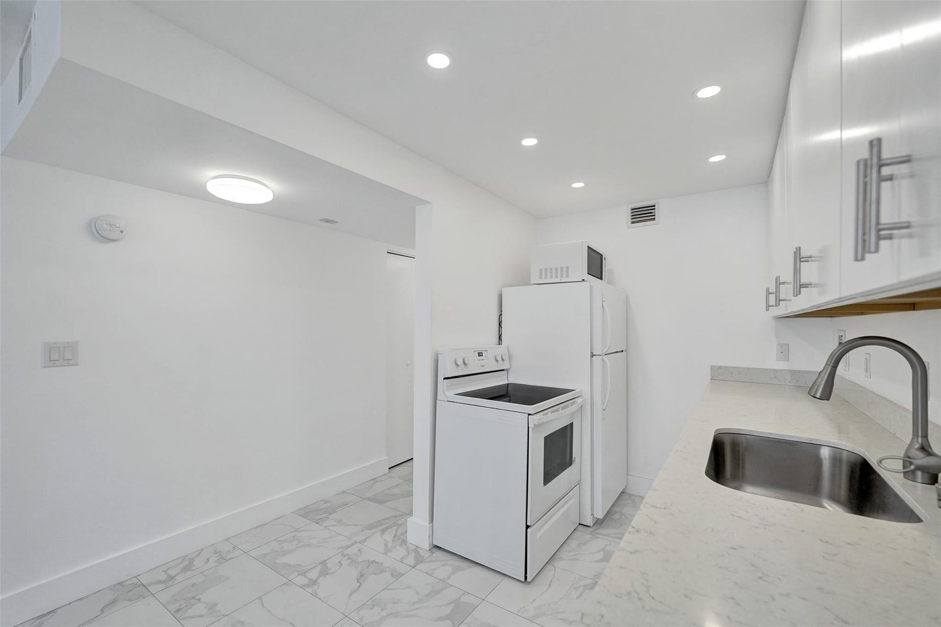 Pristine open white kitchen, Quartz counters, large sink