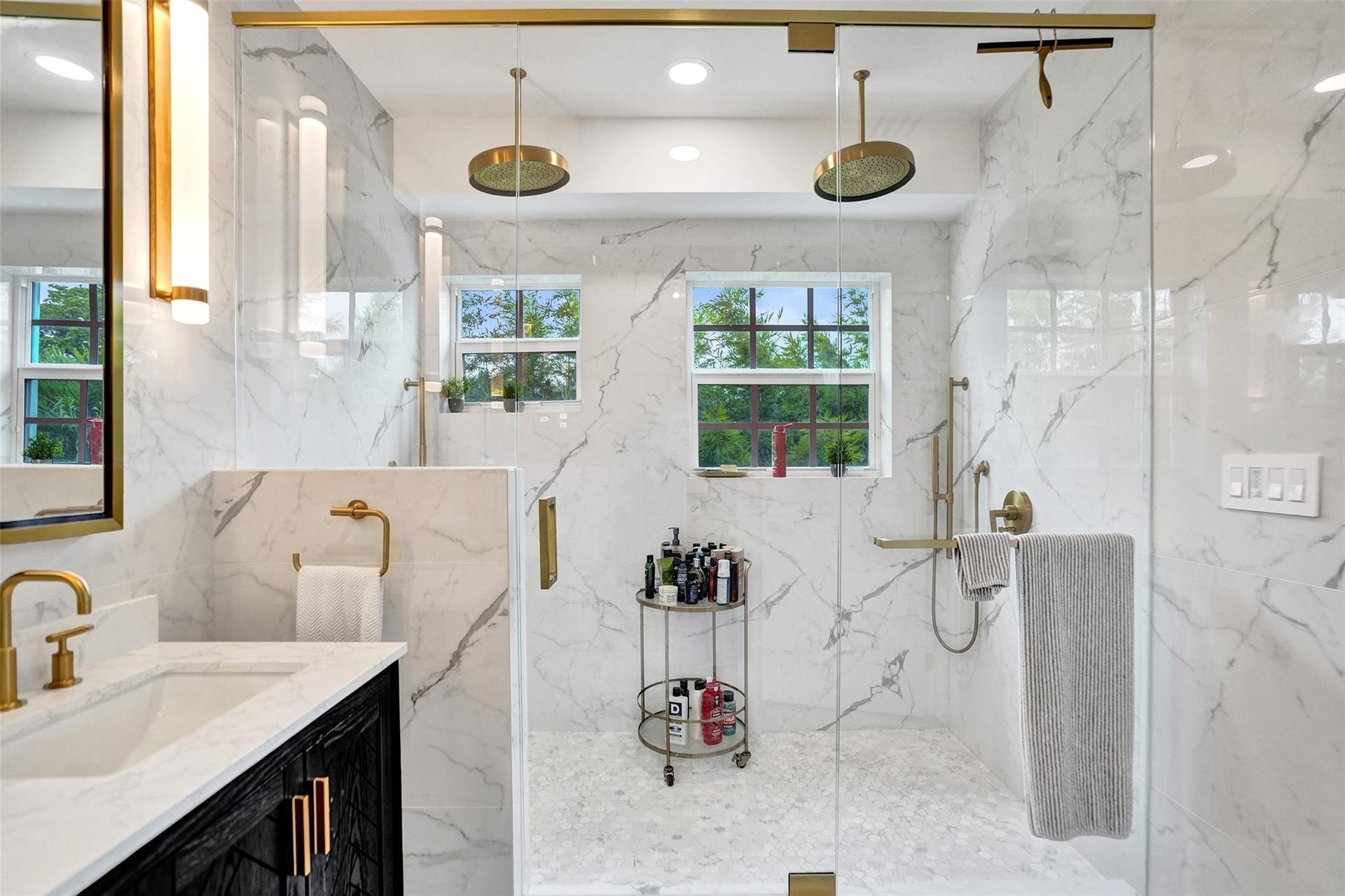 Spa-like primary bath with dual shower heads and marble tile.