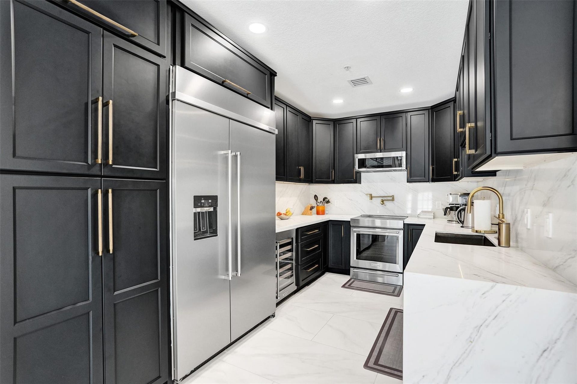 Kitchen detail with pot filler, stainless steel fridge, and wine cooler