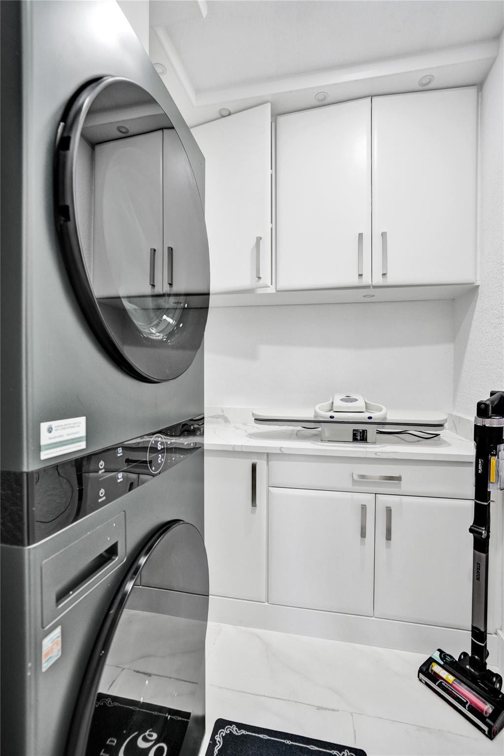 Laundry room with built in cabinets and stackable washer/Dryer