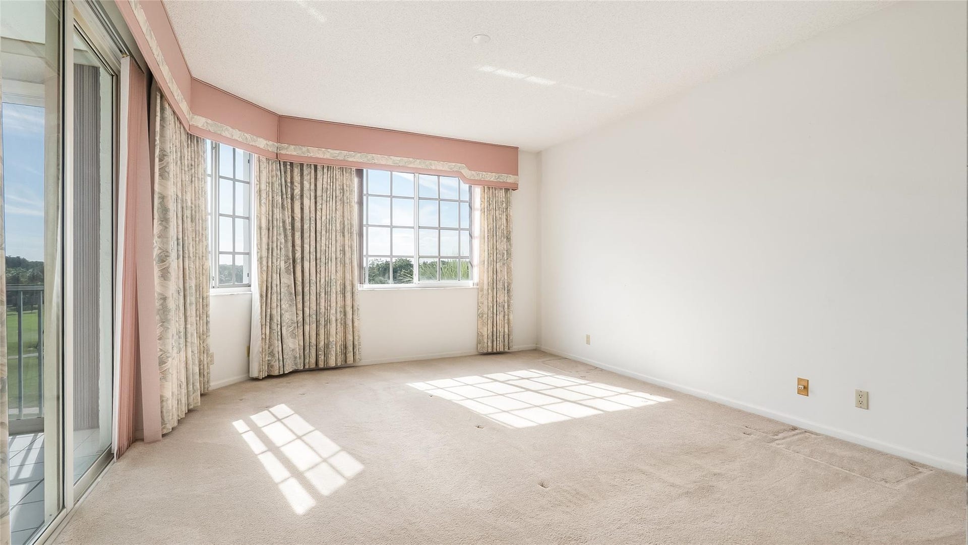 4116 W Palm Aire Drive, #165A, Pompano Beach, FL 33069 Primary bedroom with gold course views and access to enclosed balcony.