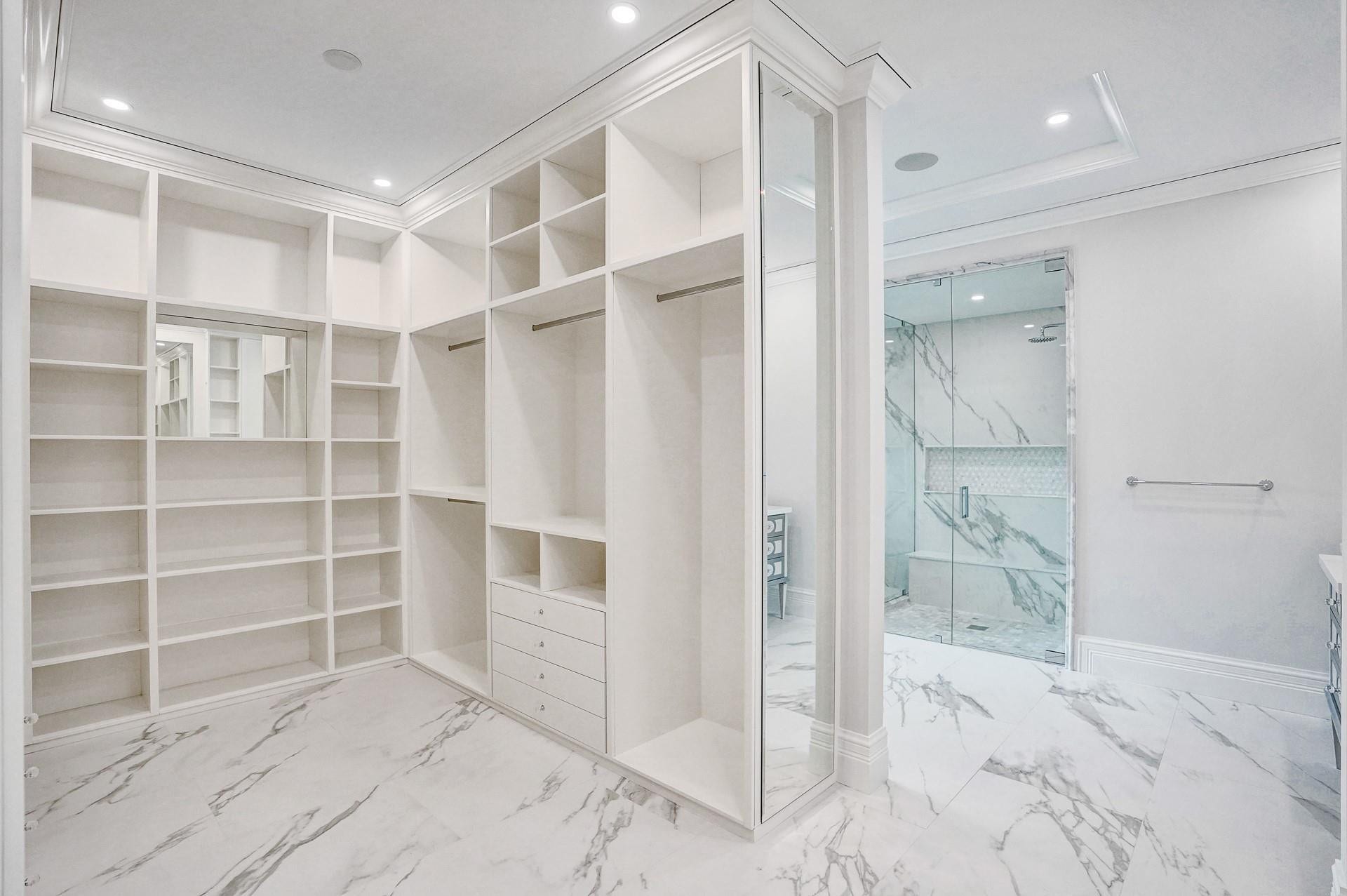The primary suite boasts separate his-and-hers bathrooms; her bathroom features a spa-like soaking tub, makeup vanity, and a spacious walk-in closet.