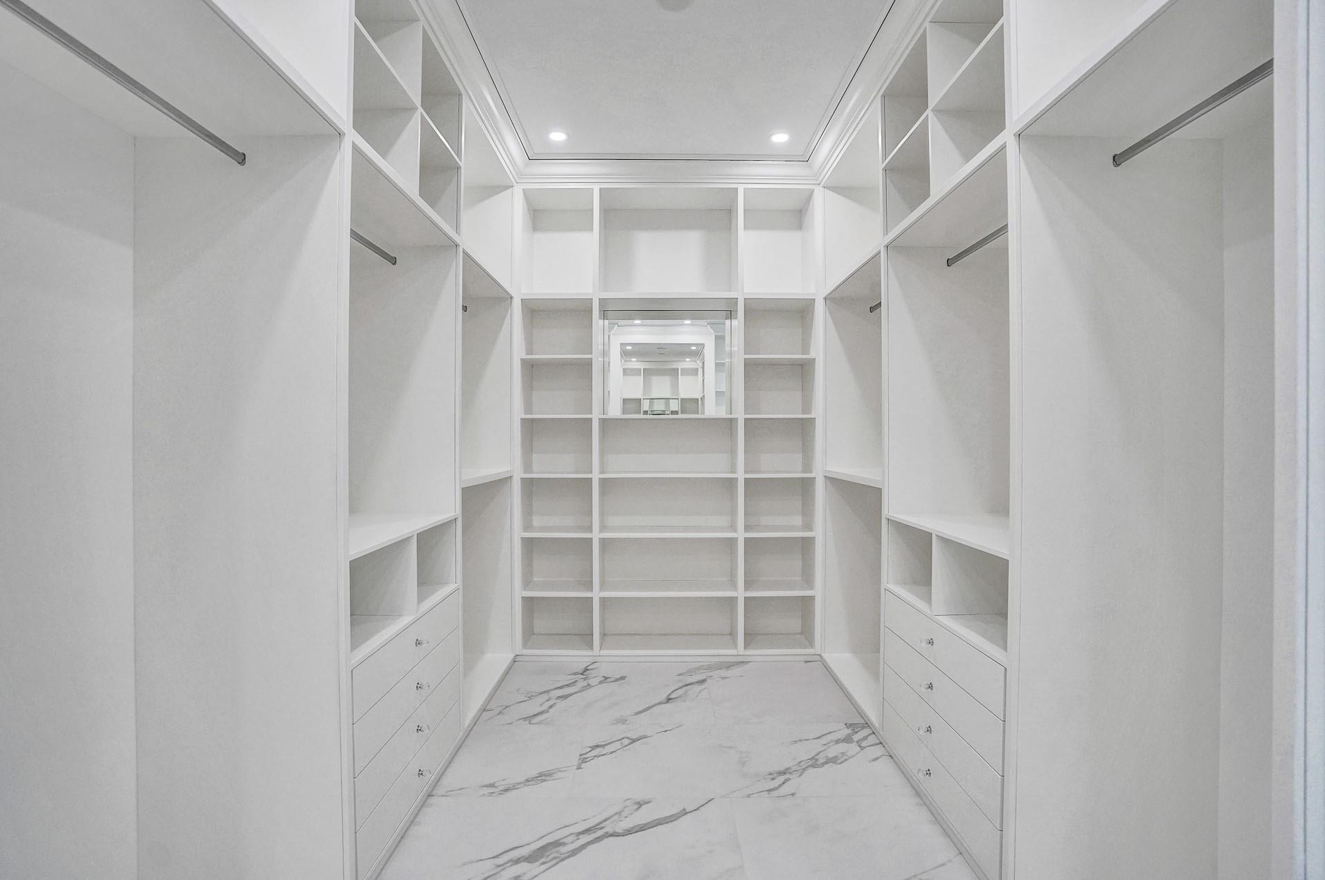 The primary suite boasts separate his-and-hers bathrooms; her bathroom features a spa-like soaking tub, makeup vanity, and a spacious walk-in closet.