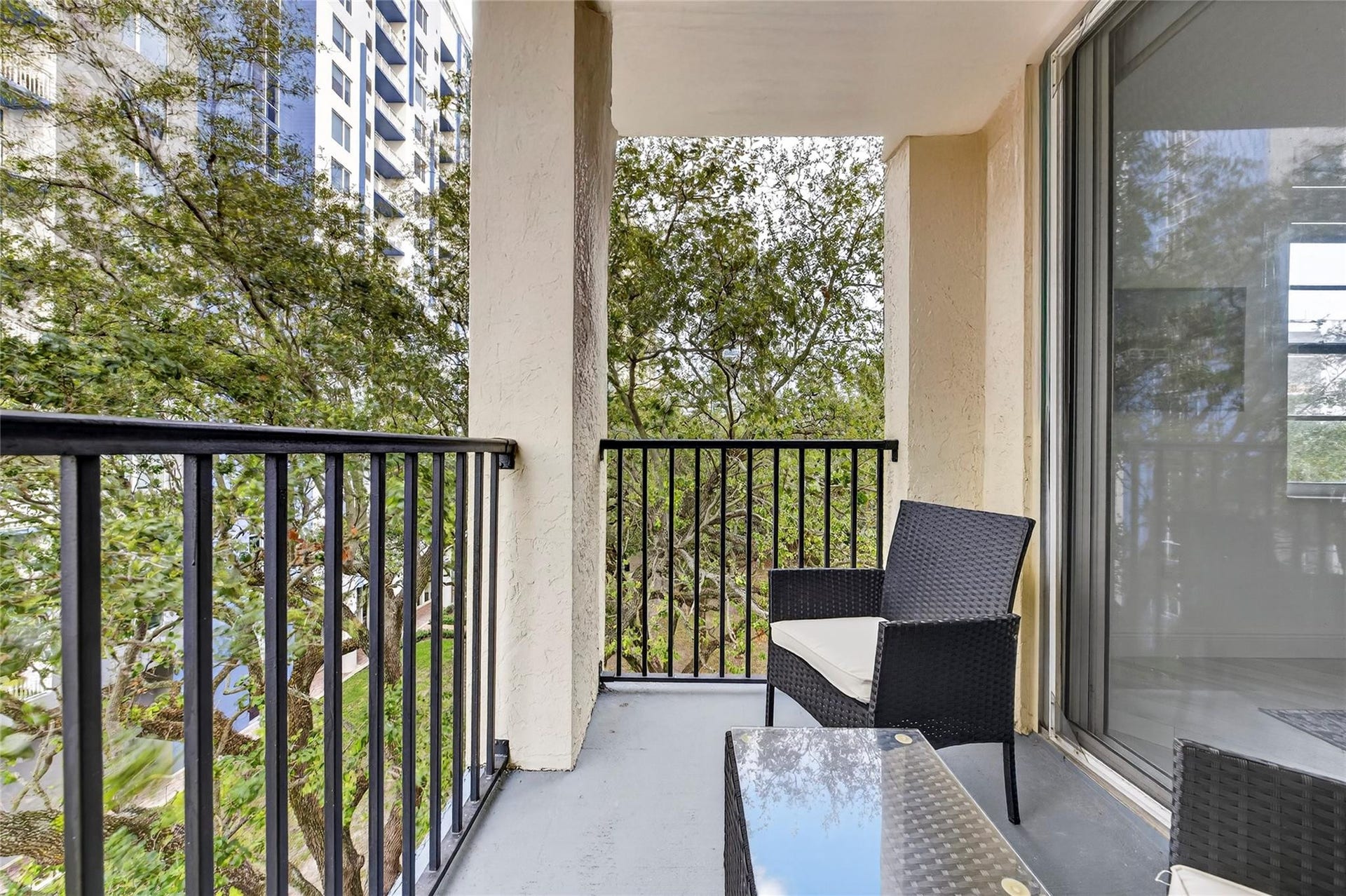 520 SE 5th Avenue, #2404, Fort Lauderdale, FL 33301 Private primary patio offers a peaceful retreat with leafy treetop viewsperfect for morning coffee or unwinding in the evening.