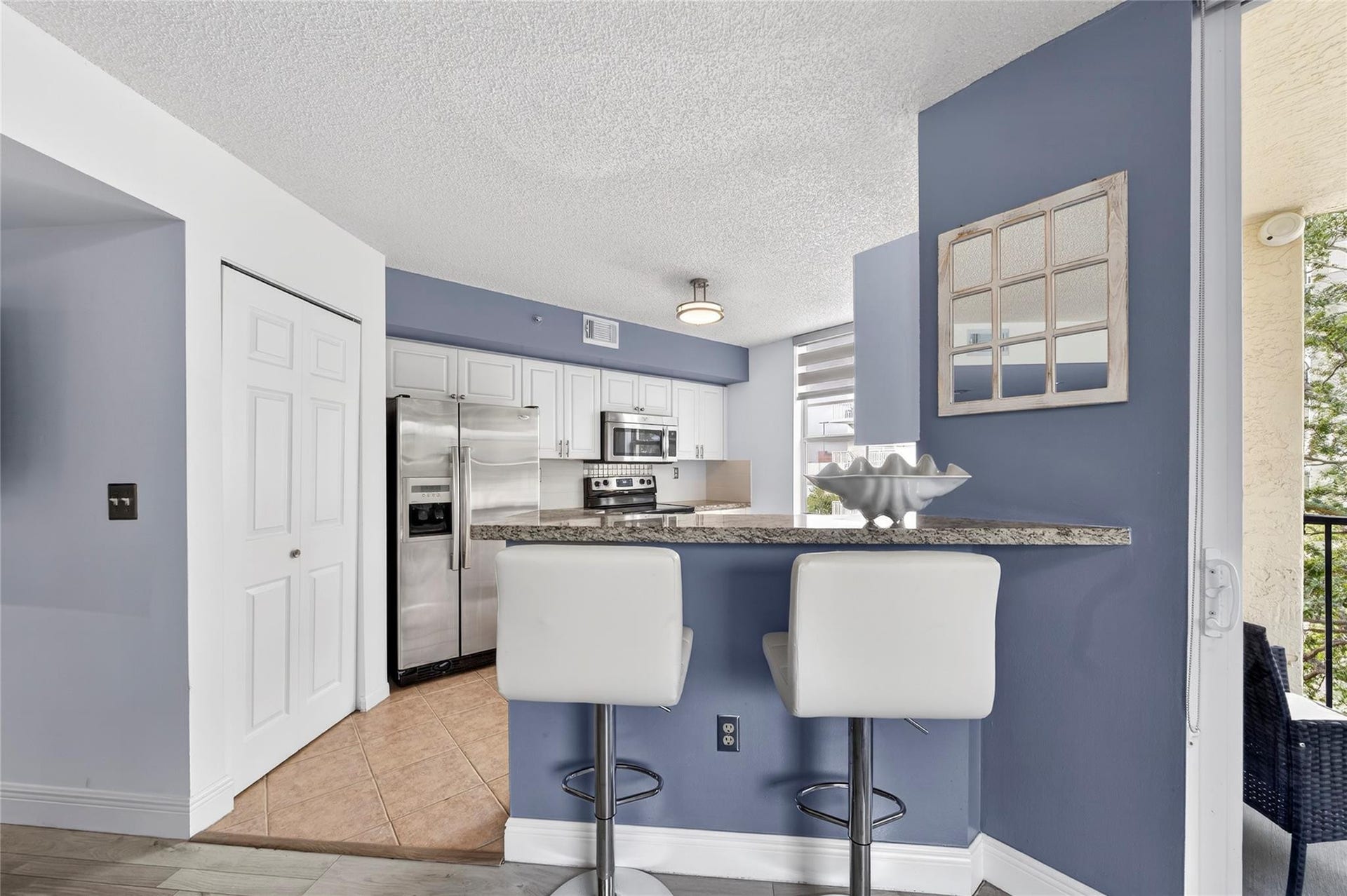 520 SE 5th Avenue, #2404, Fort Lauderdale, FL 33301 Updated kitchen features stainless steel appliances, granite countertops, and a custom tile backsplash, seamlessly connected to the living space and breakfast bar for easy everyday living and entertaining.