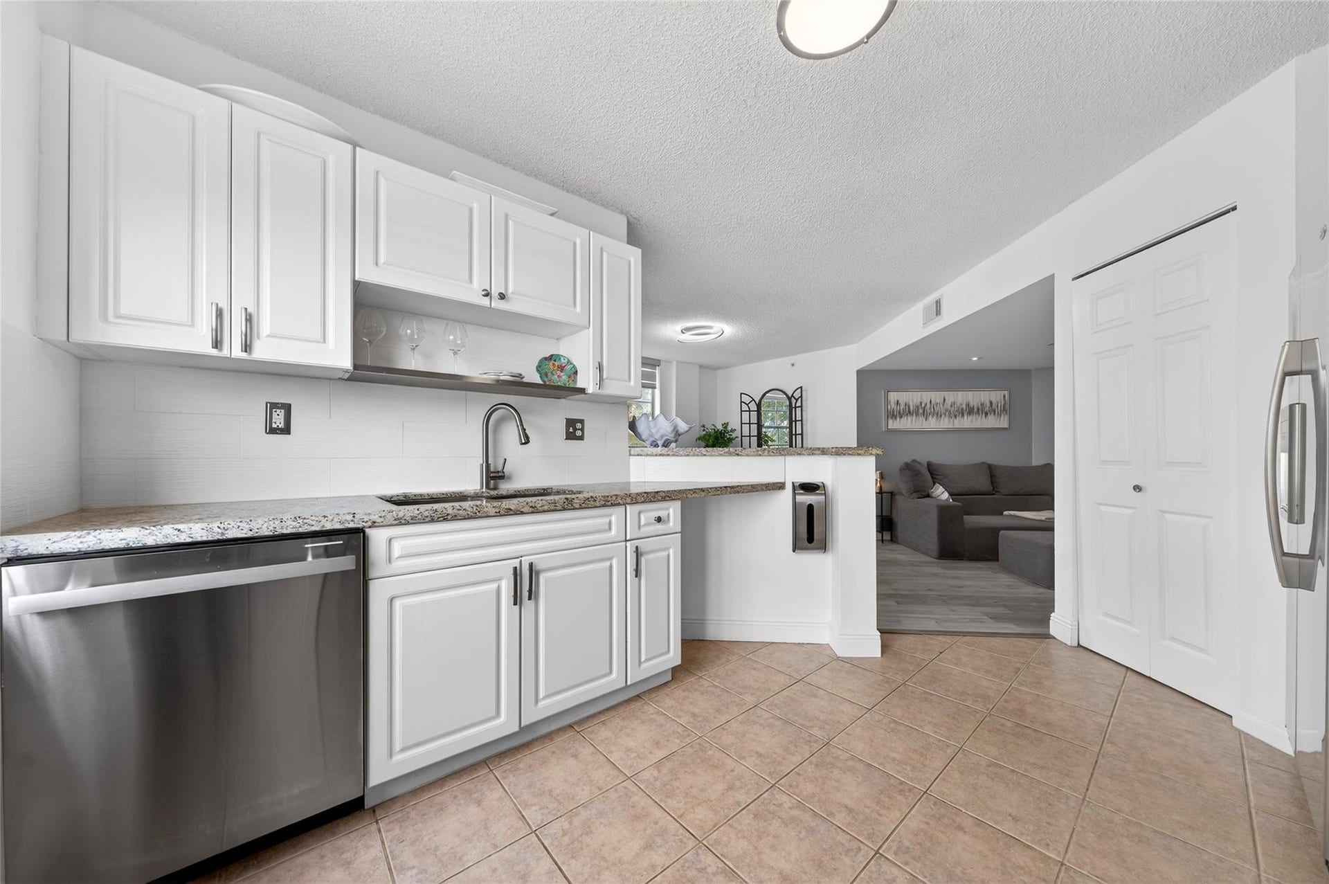520 SE 5th Avenue, #2404, Fort Lauderdale, FL 33301 Updated kitchen features stainless steel appliances, granite countertops, and a custom tile backsplash, seamlessly connected to the living space and breakfast bar for easy everyday living and entertaining.