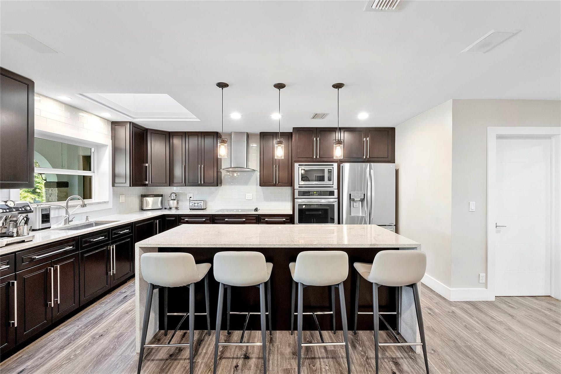 5351 Godfrey Road, Parkland, FL 33067 Granite countertops with a waterfall drop on both sides, Subway backsplash with stainless gourmet hood,