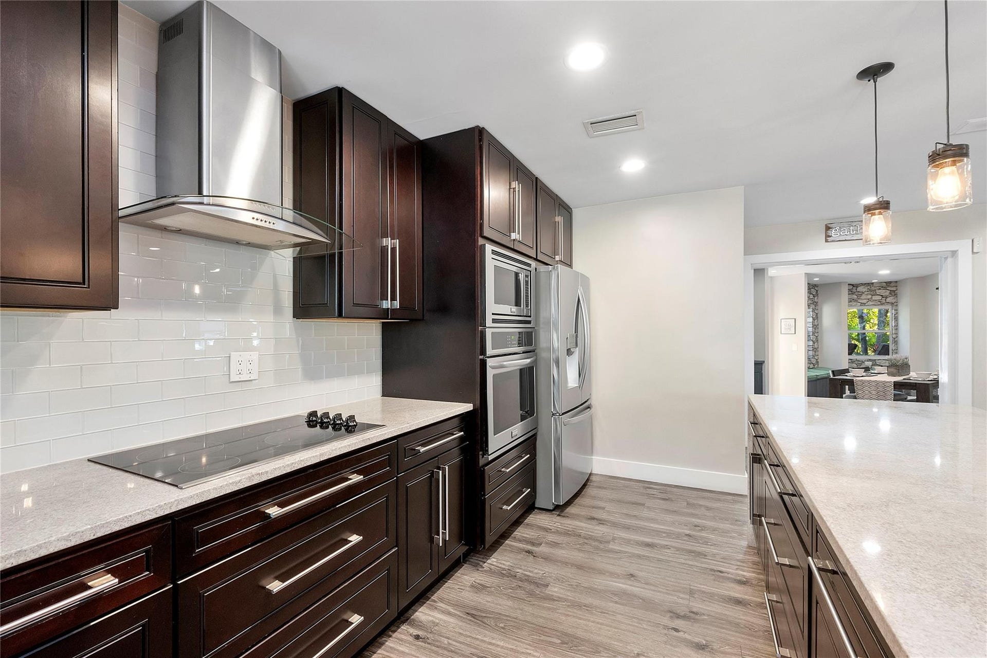 5351 Godfrey Road, Parkland, FL 33067 Walnut cabinets & pendant lighting, Stainless steel appliances & granite countertops in the main kitchen,