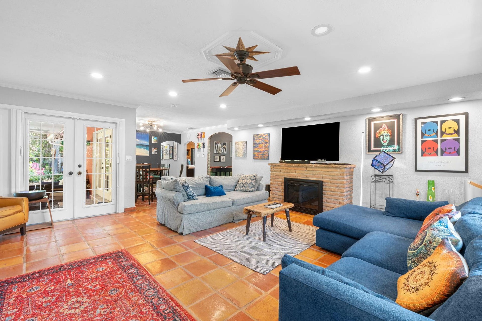2956 NW 6th Terrace, Wilton Manors, FL 33311 Open-concept living and dining areas with crown molding, ceiling fan, and recessed HUE lighting throughout. French doors extend the living space to the outdoor patio.