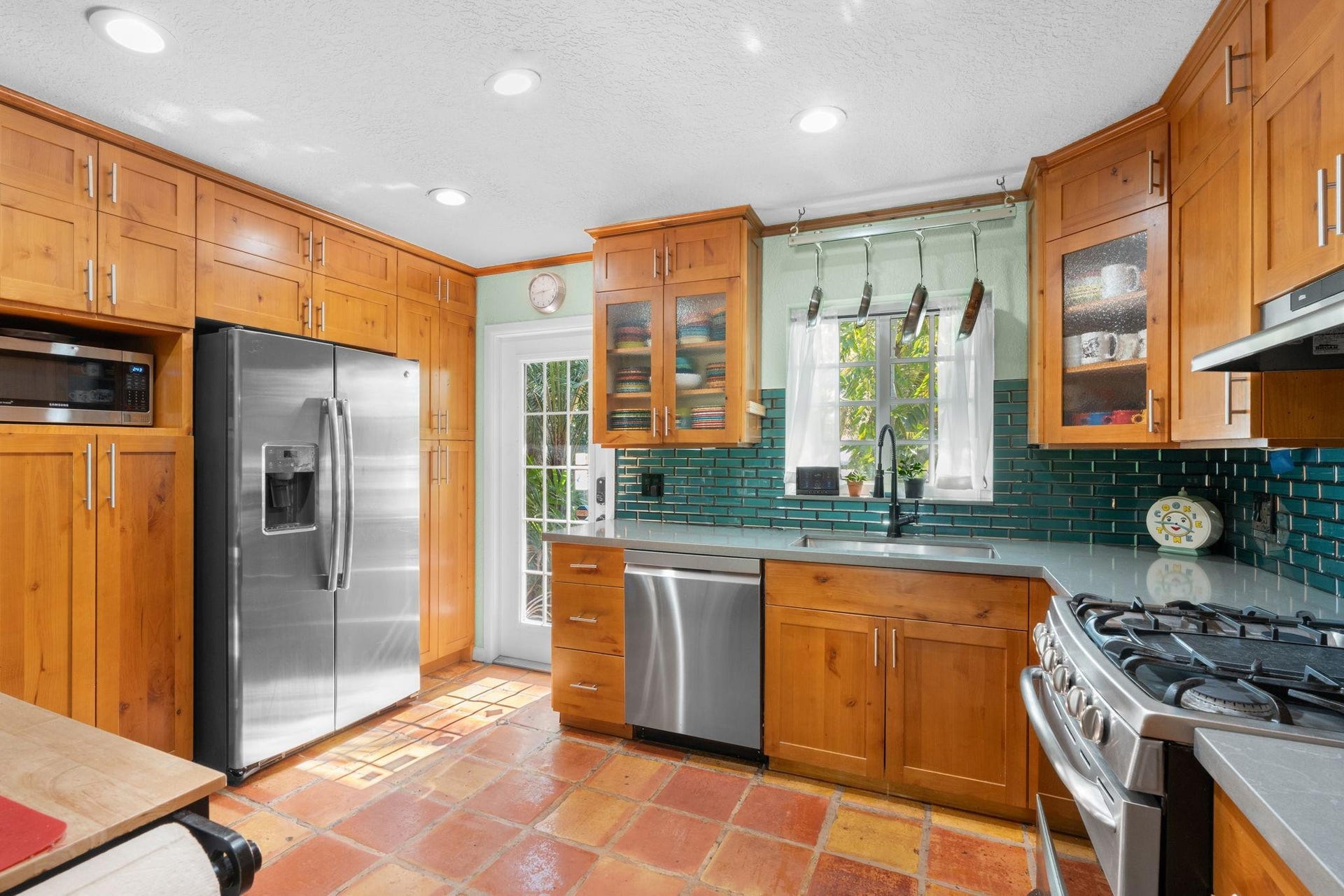 2956 NW 6th Terrace, Wilton Manors, FL 33311 Well-appointed kitchen with gas range, stainless steel refrigerator, and dishwasher. Abundant cabinet storage and glass-front uppers add character and practicality.