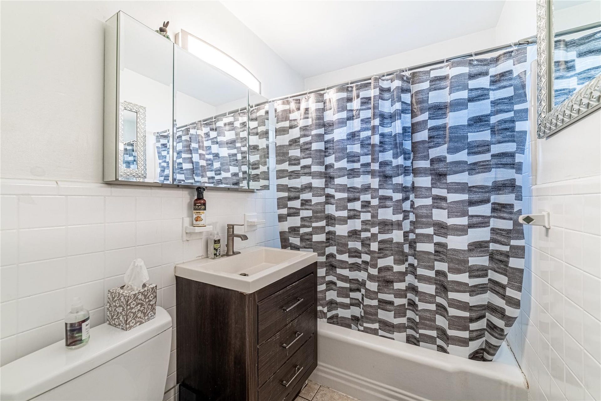 Bathroom is located in the hallway by the two bedrooms.