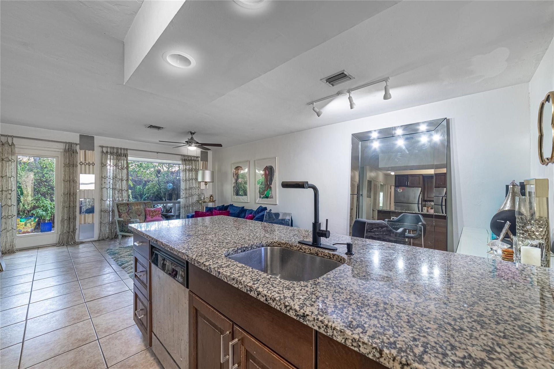 Unit 1013 kitchen to living area and outdoor patio. Dining area to the right of kitchen island.