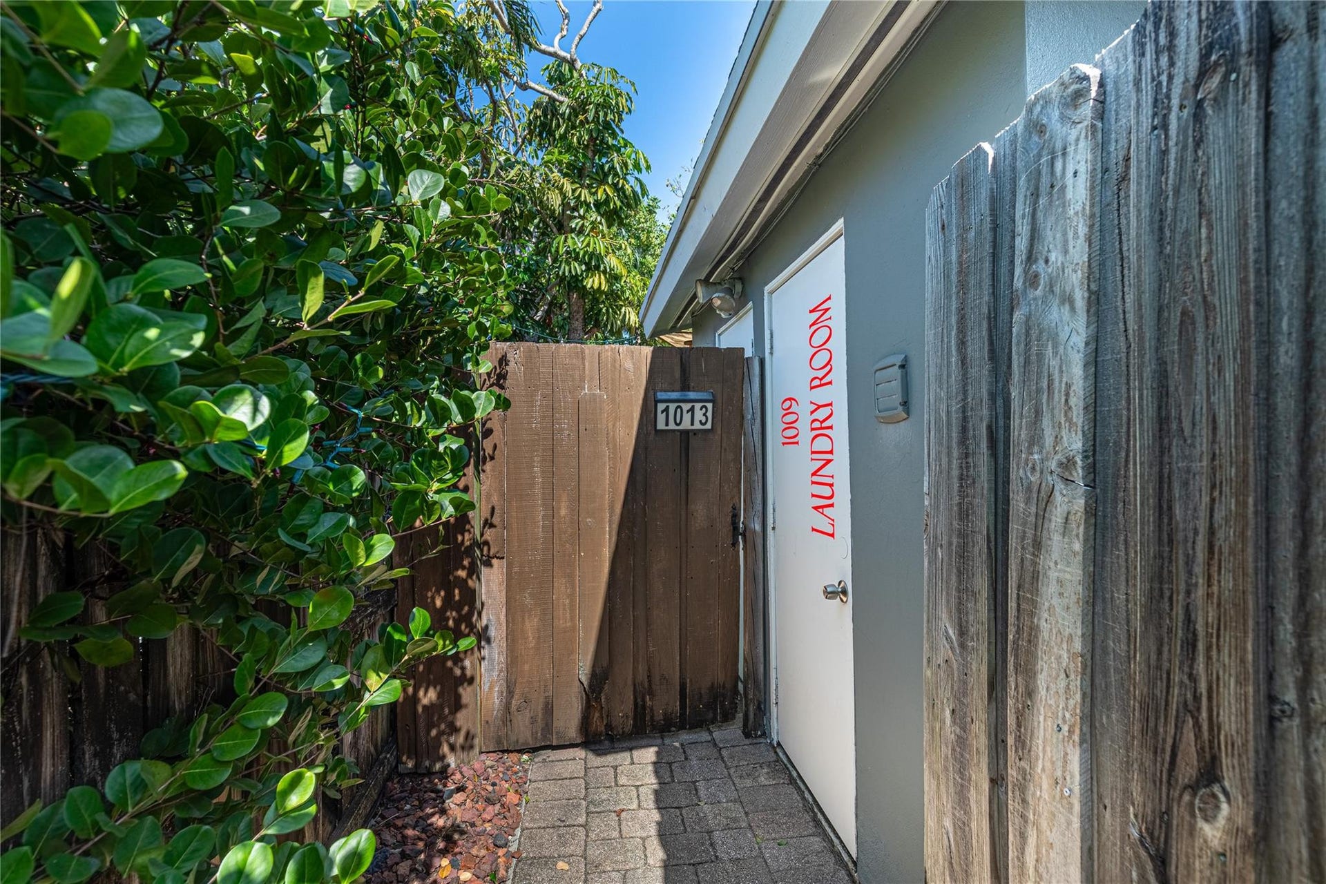 Gate to enter unit 1013 which runs along the back of the property. Locked, private laundry closet for Unit 1009 which is accessed through the gate on the right.