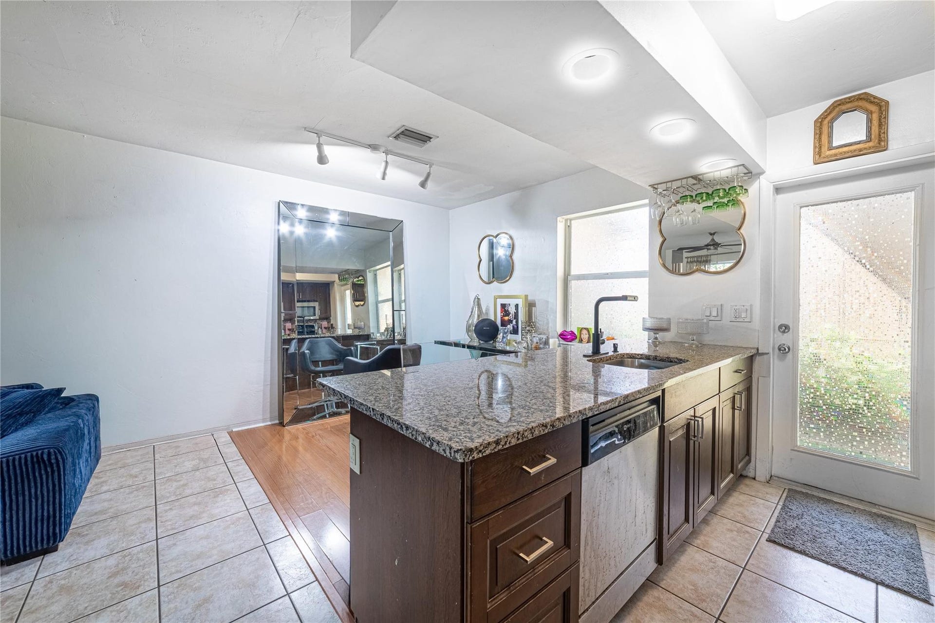 Unit 1013 kitchen, dining area. Unit entry door to the right. Kitchen has granite and stainless steel appliances.