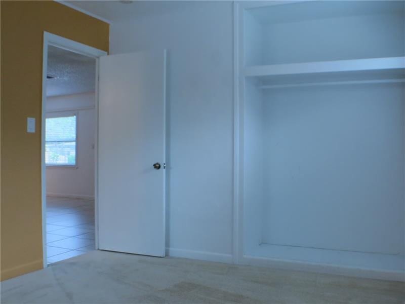 Exterior Front. Guest bedroom 2, with closet, also carpeted.