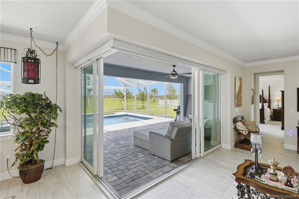 Expansive corner sliding glass doors create a seamless transition between indoor and outdoor living spaces, opening to a covered lanai, screened pool, and peaceful preserve views. This exceptional design fills the home with natural light and provides the perfect setting for entertaining or relaxing in true Florida style.