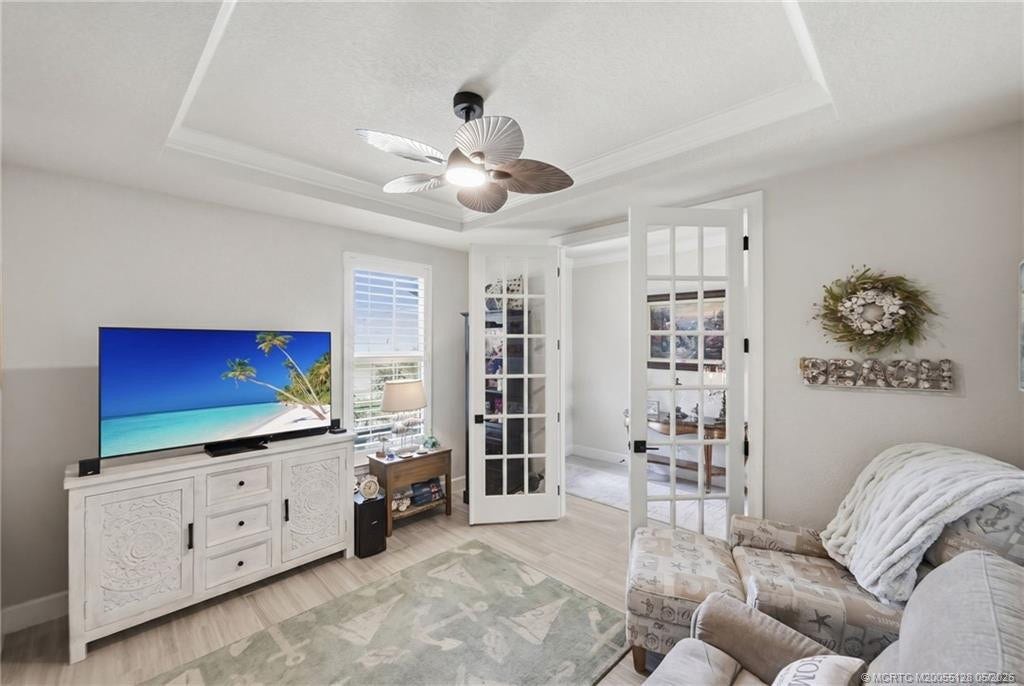 Versatile flex room with elegant glass French doors offers the perfect space for a home office, den, media room, or additional guest accommodations. Features include tray ceiling detail, crown molding, abundant natural light, and stylish finishes that complement the homes open and modern design.