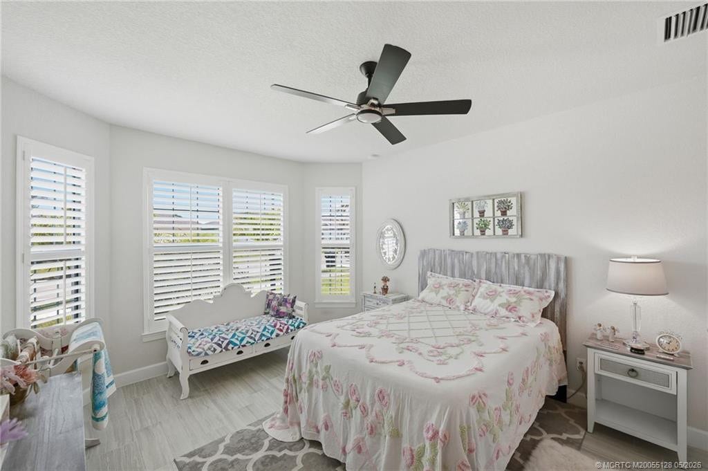 Spacious primary suite offers a peaceful retreat with elegant tile flooring, plantation shutters, abundant natural light, and a bright, airy design. Generous layout provides plenty of room for relaxing while complementing the homes modern coastal style and luxurious feel.
