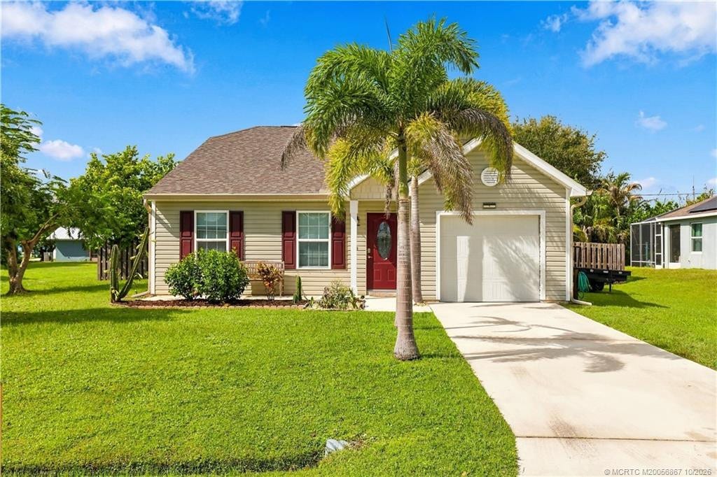 2134 SE Gaslight Street, Port St Lucie, FL 34952 Alternate view of front elevation showing driveway and palm tree landscaping