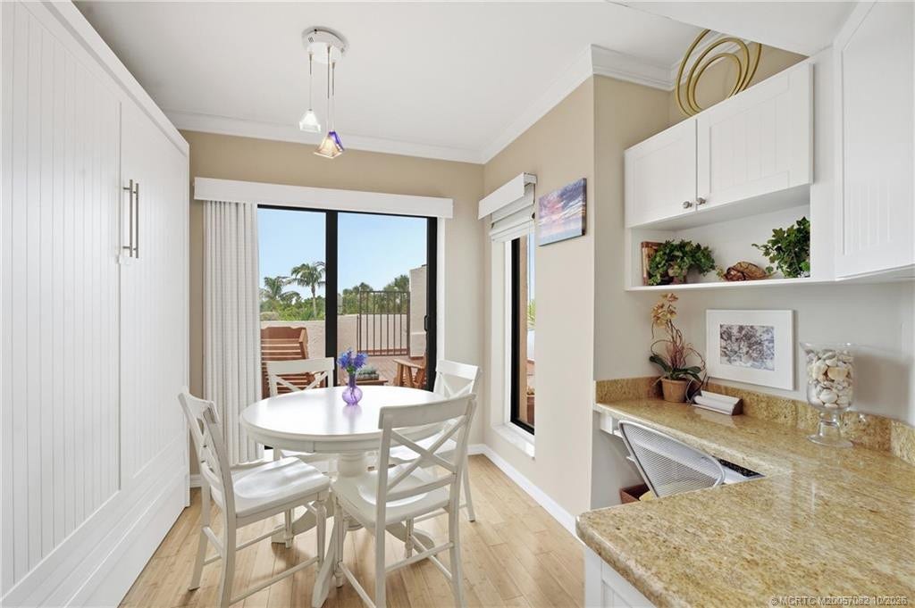 Casual dining area off the kitchen overlooks the private courtyard and includes a built-in desk/workspace and murphy bed.