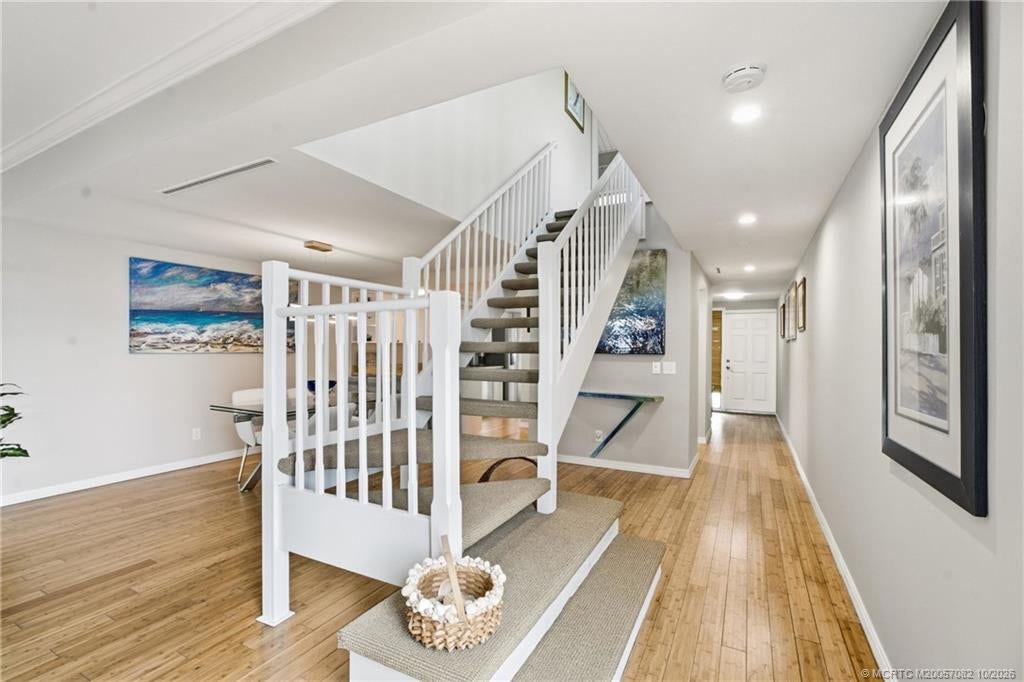 Open staircase leads to the upper-level bedrooms while maintaining the bright, airy feel of the main living level.