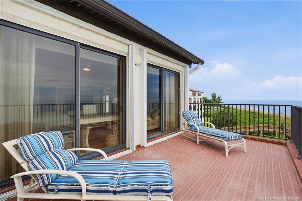 Expansive brick terrace off the primary suite with wide, unobstructed views of the beach and Atlantic Ocean.