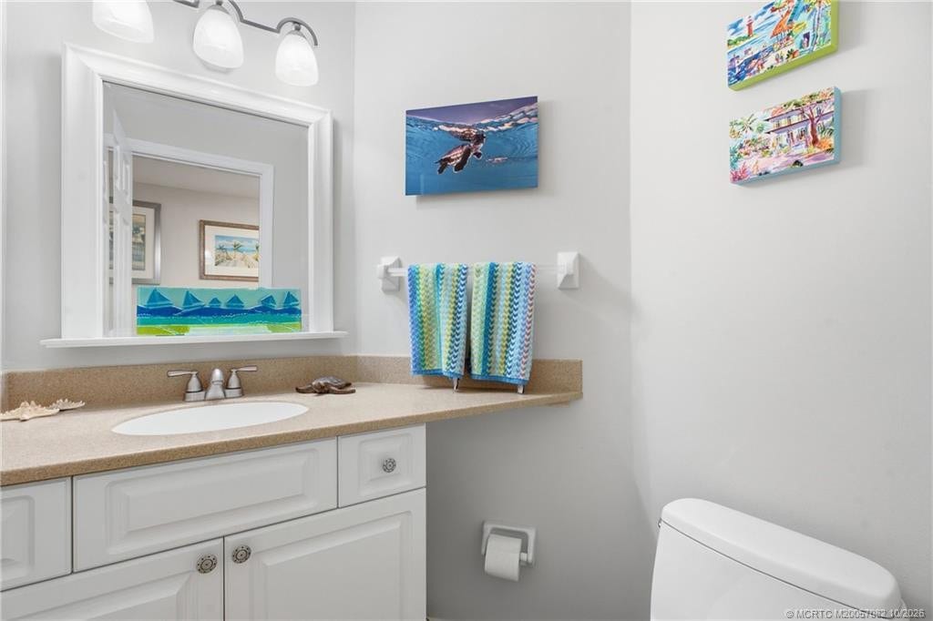 Convenient downstairs half bath with a spacious vanity and coastal-inspired dcor.