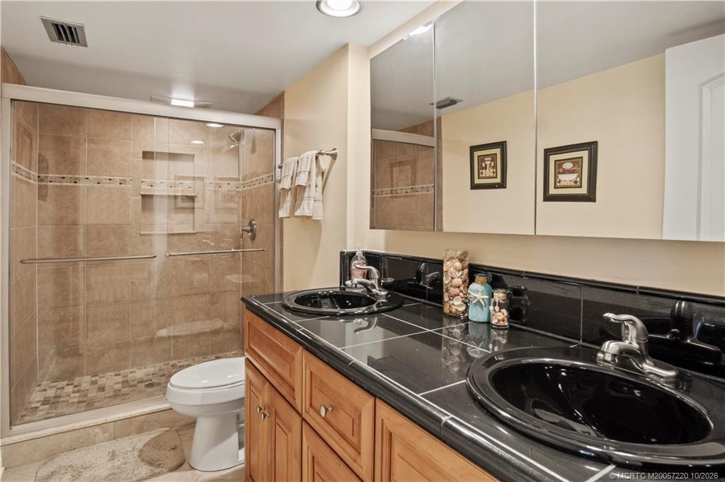 1800 SE Saint Lucie Boulevard, #9-105, Stuart, FL 34996 Tiled walk in shower with double sinks on granite countertops