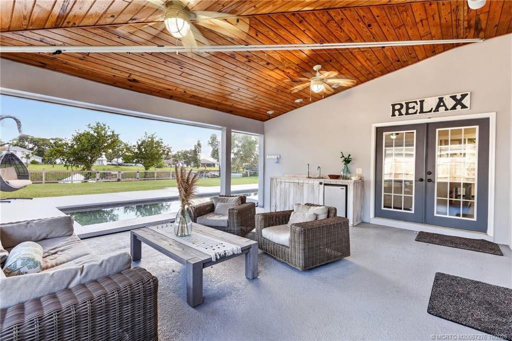 2657 SW Harem Circle, Port St Lucie, FL 34953 Expansive covered outdoor living area with beautiful wood ceiling, sink, and views of the sparkling pool and canal.