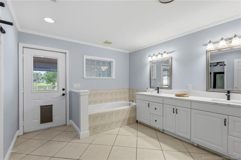2657 SW Harem Circle, Port St Lucie, FL 34953 Spacious primary bath with double vanities, a soaking tub, and convenient access to the outdoor living areas.