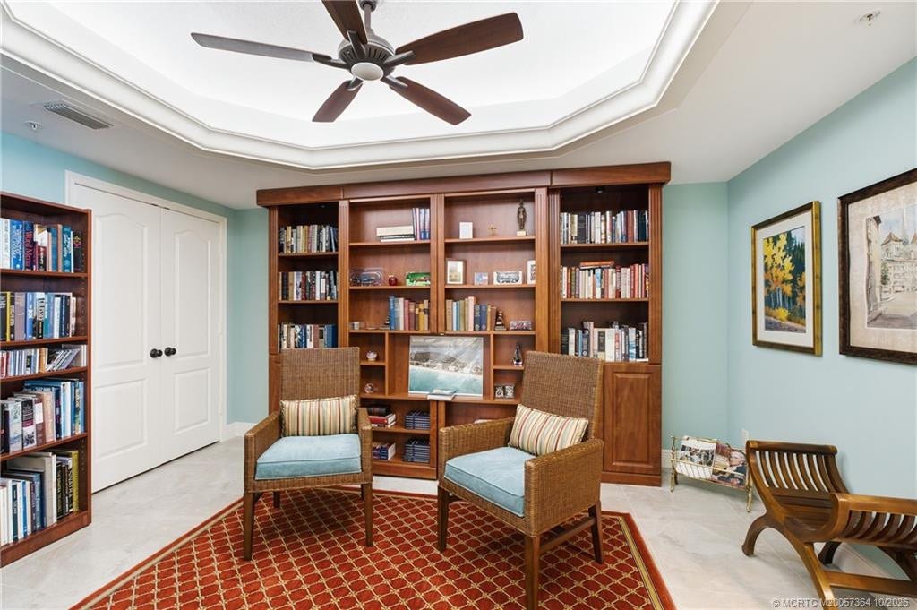 Spacious library with extensive built-in shelving and a concealed Murphy bed, offering the flexibility of a home office and guest bedroom.