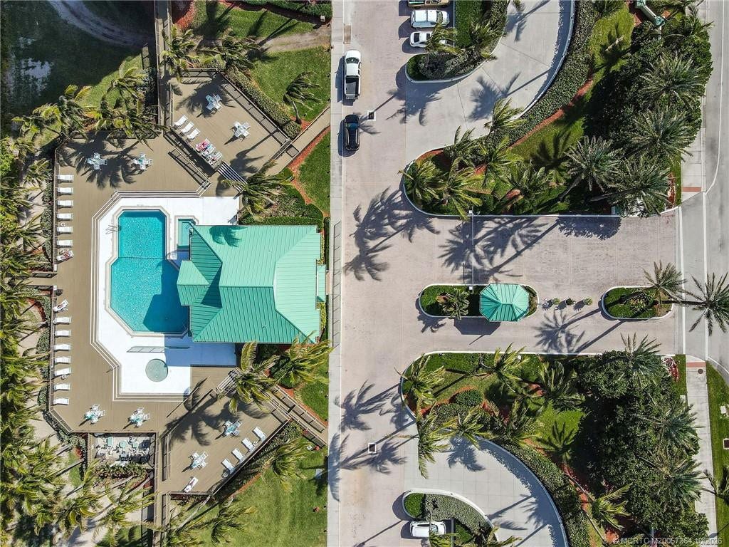 Overhead view showcasing the beautifully landscaped pool area, spacious sun decks, and convenient community parking.