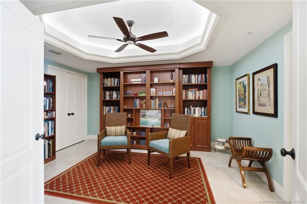 Versatile library featuring a built-in Murphy bed, custom wood cabinetry, and a beautiful tray ceiling. Perfect for accommodating overnight guests.
