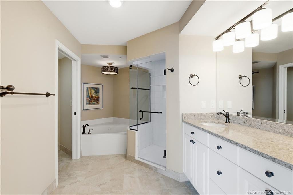 Primary bathroom offers a separate soaking tub, walk-in shower, and generous vanity space.