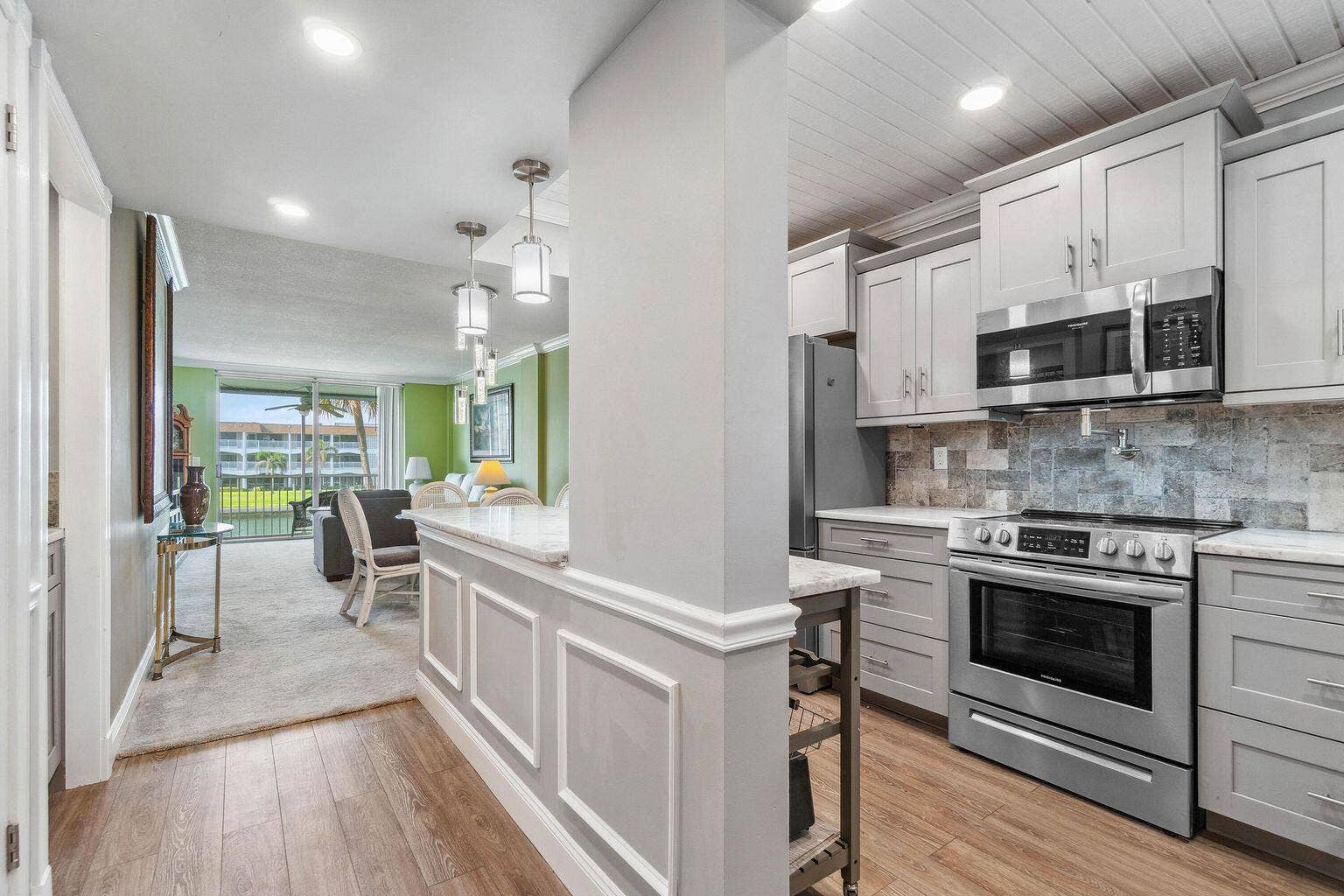 100 Paradise Harbour Boulevard, #208, North Palm Beach, FL 33408 Updated and open kitchen boasts shaker style cabinets, quartz countertops and stainless steel appliances