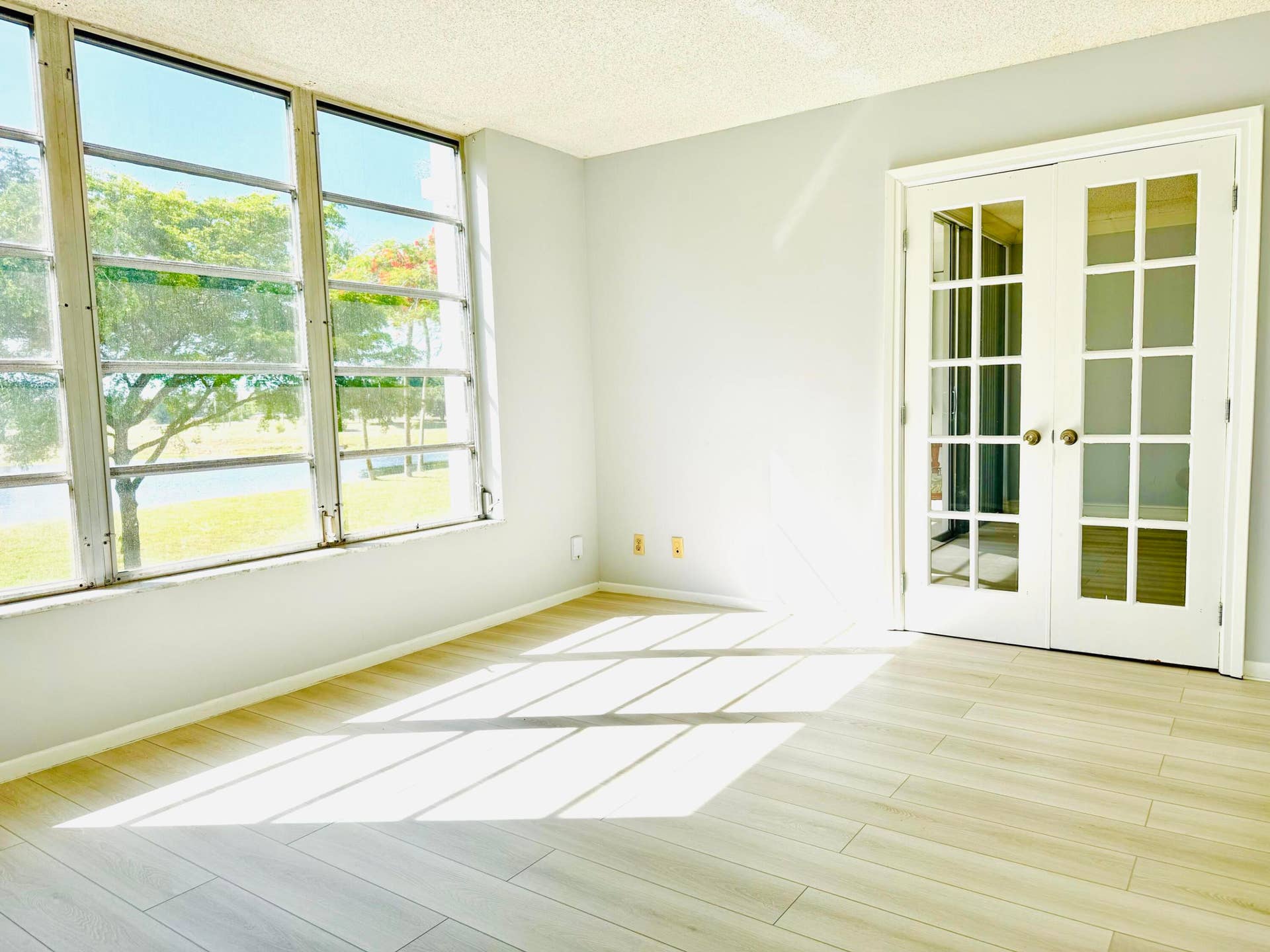 3080 N Course Drive, #202, Pompano Beach, FL 33069 Second bedroom with extra large picture window and French doors leading to living area