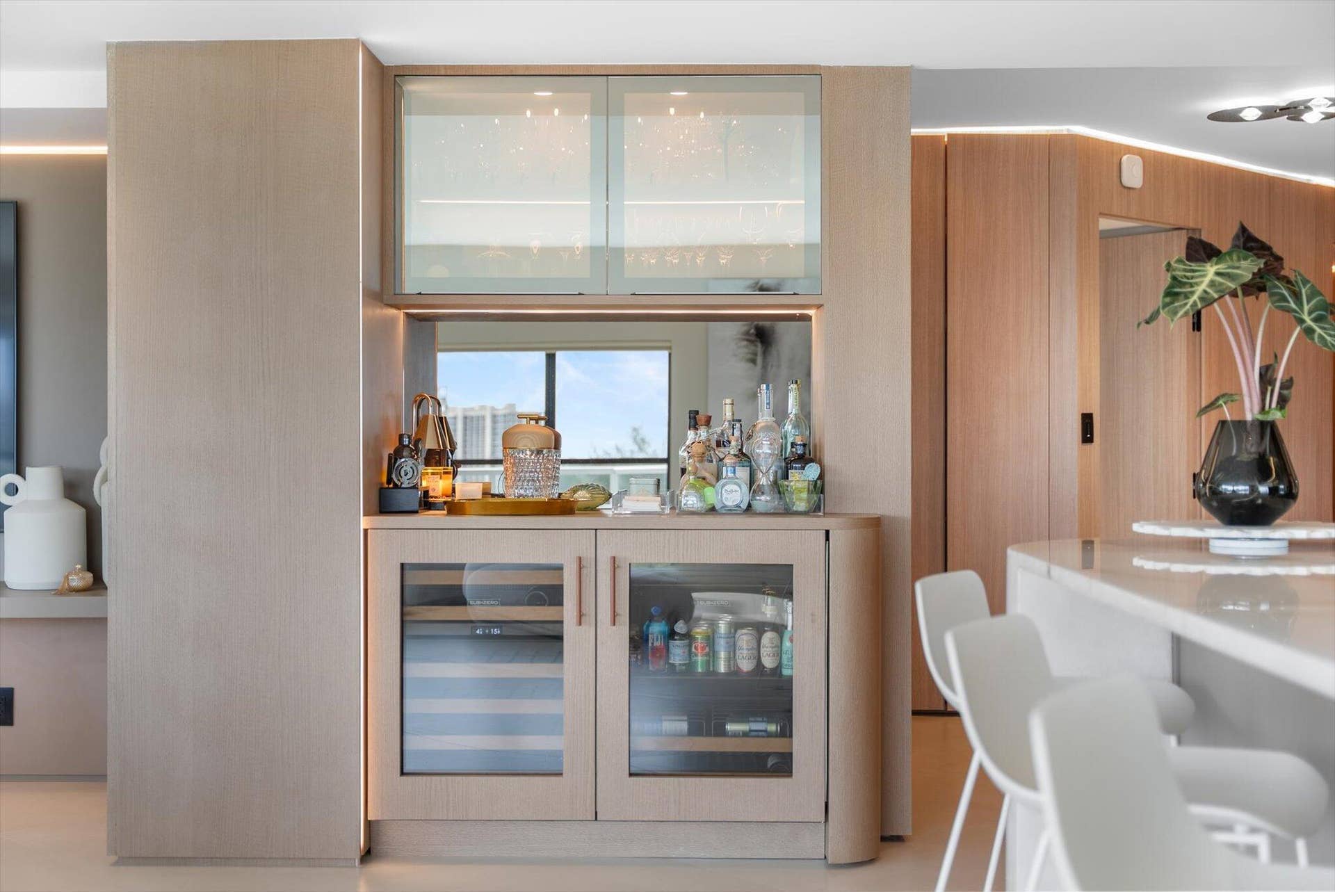 Wet bar with Subzero Wine Refrigerator and Beverage Center and Custom Wood and Glass Design