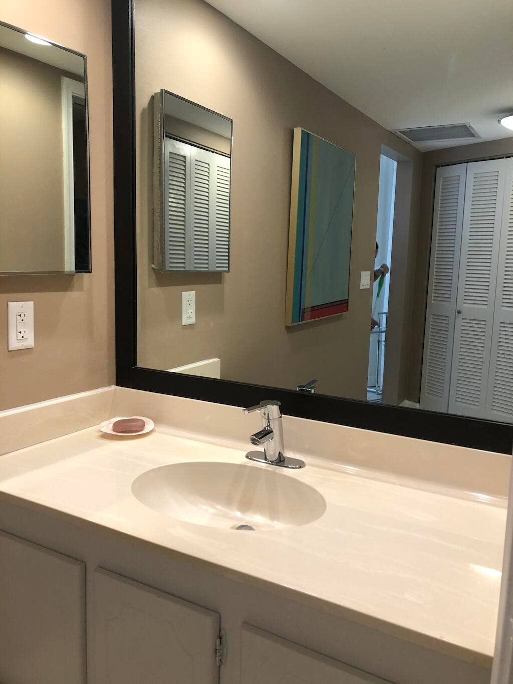 Vanity featuring an integrated sink, polished chrome faucet, and white cabinetry