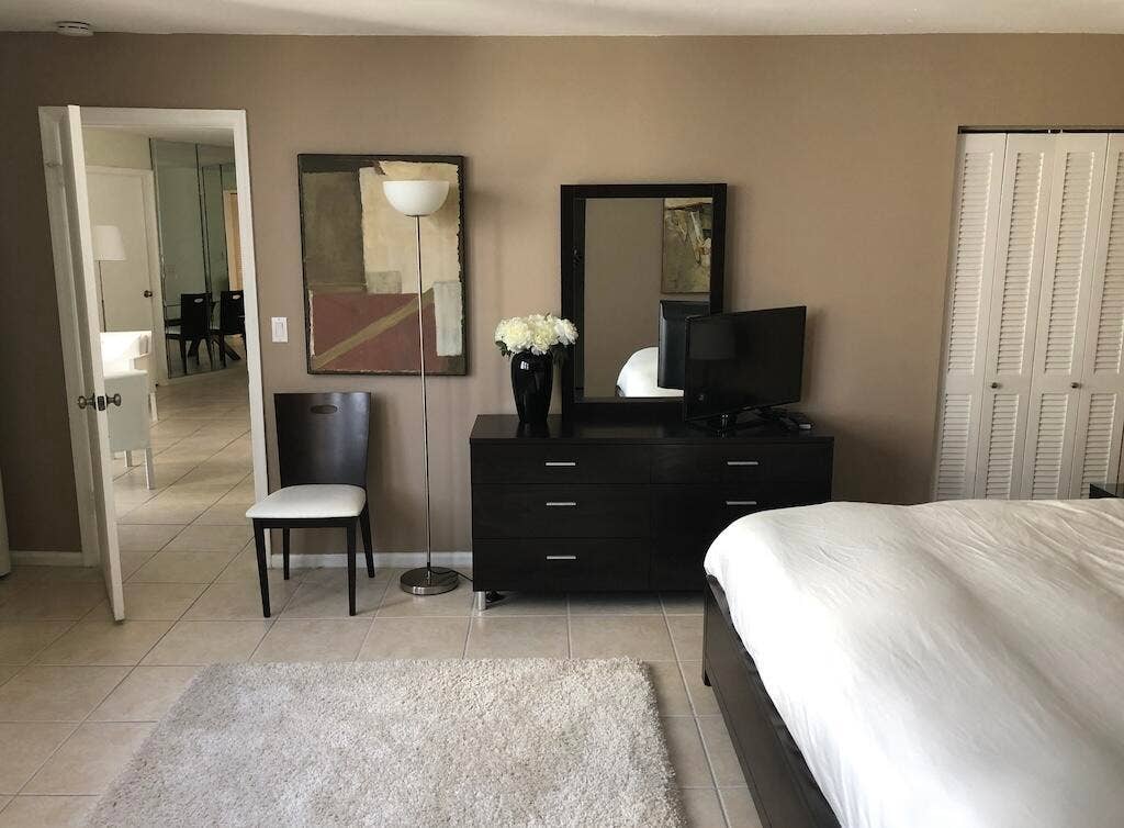 Ceramic tile flooring, neutral wall tones, white louvered bifold closet doors, and recessed doorway