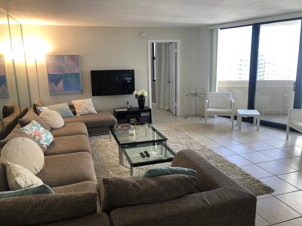 Tile flooring throughout, full-height mirrored wall, and sliding glass doors to exterior