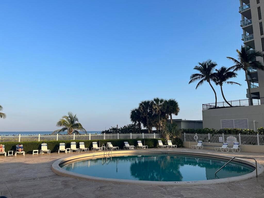 Circular swimming pool with integrated steps, surrounded by a paved deck