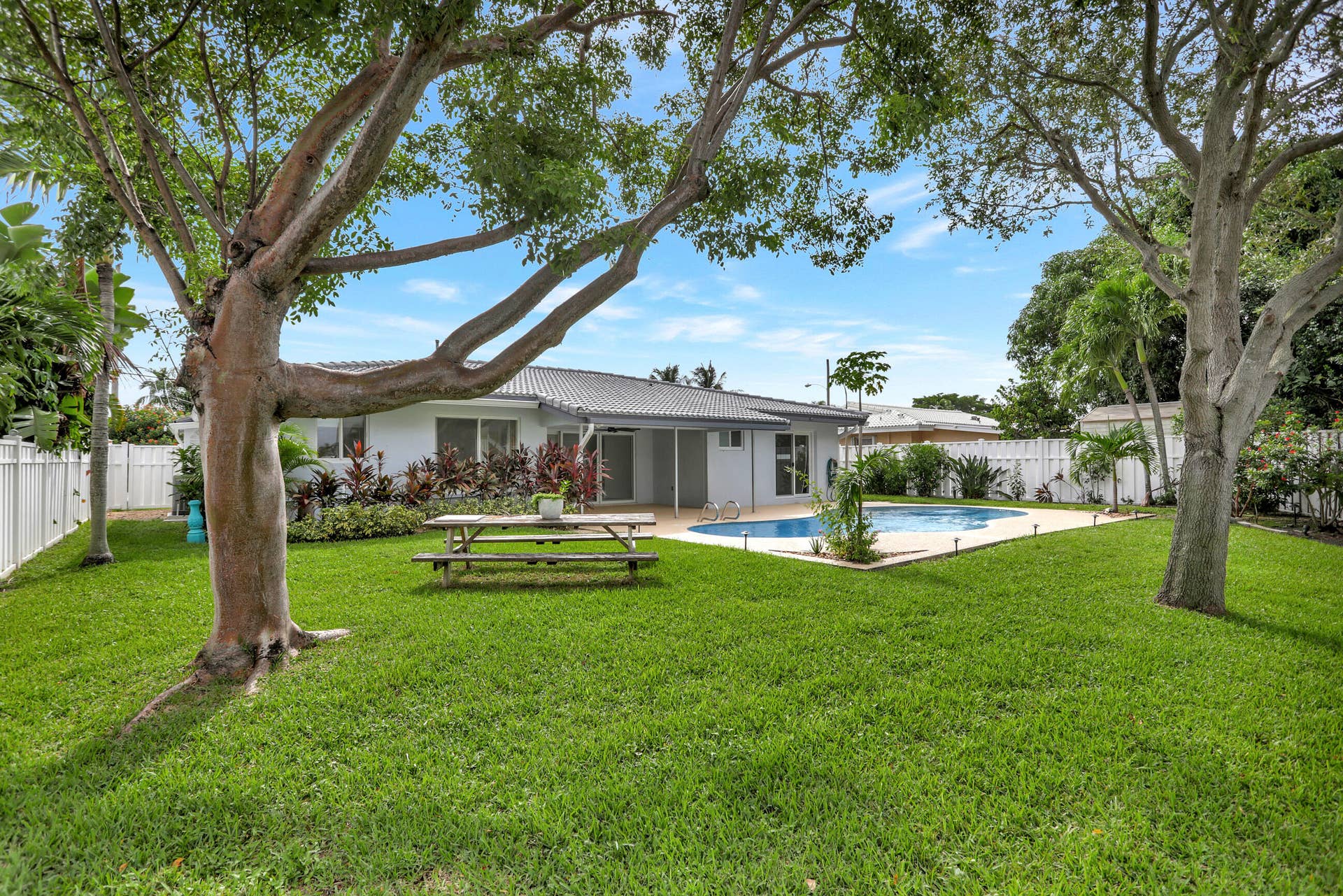 421 SE 5 Terrace, Pompano Beach, FL 33060 Large yard with privacy fence on both sides, water view and pool, deck and covered patio. Room to add a bedroom.