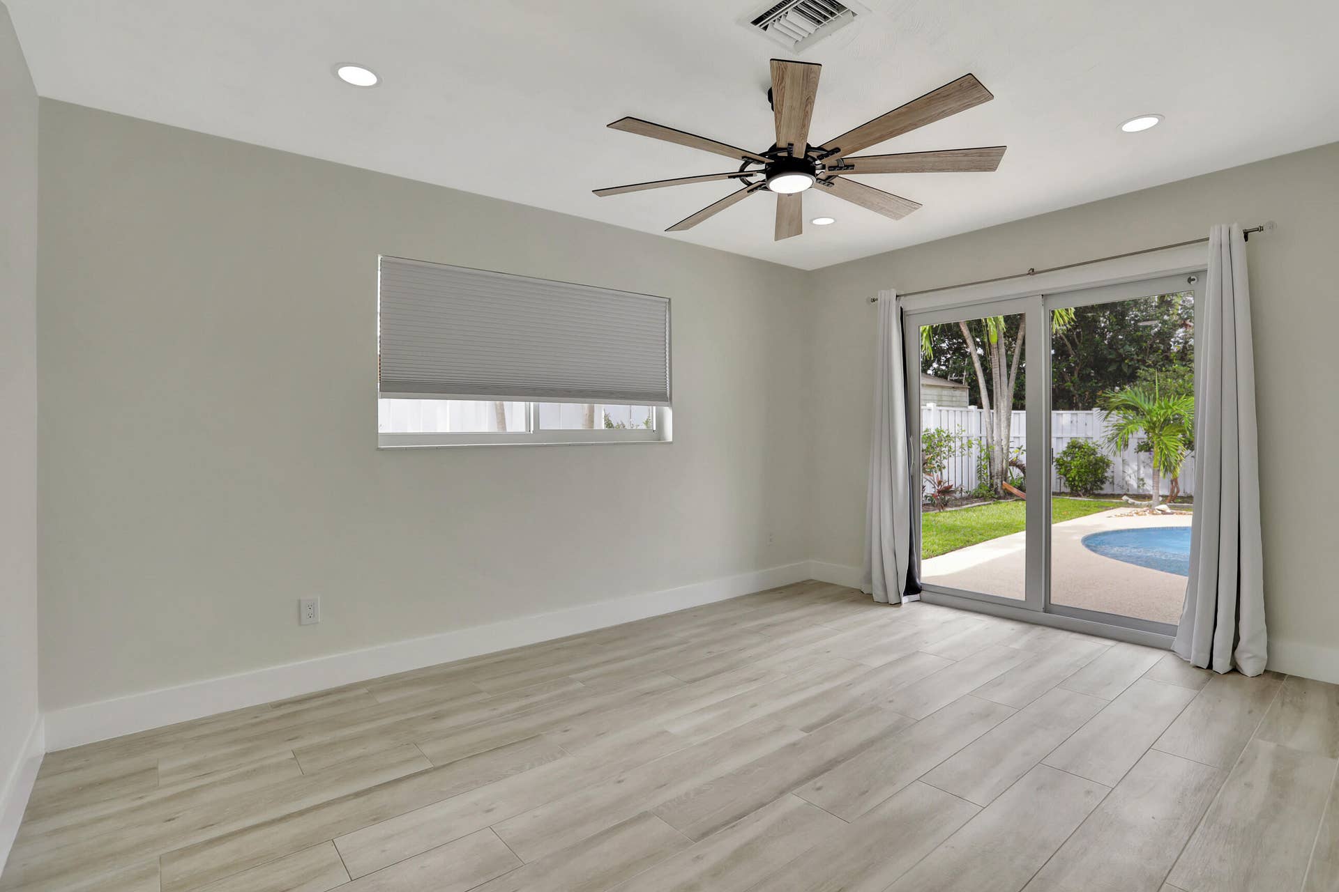 421 SE 5 Terrace, Pompano Beach, FL 33060 Bedroom facing the pool and water can be Primary Suite or Bedroom #2. Both bedrooms have full bathrooms. Storm sliders lead to the pool and deck.