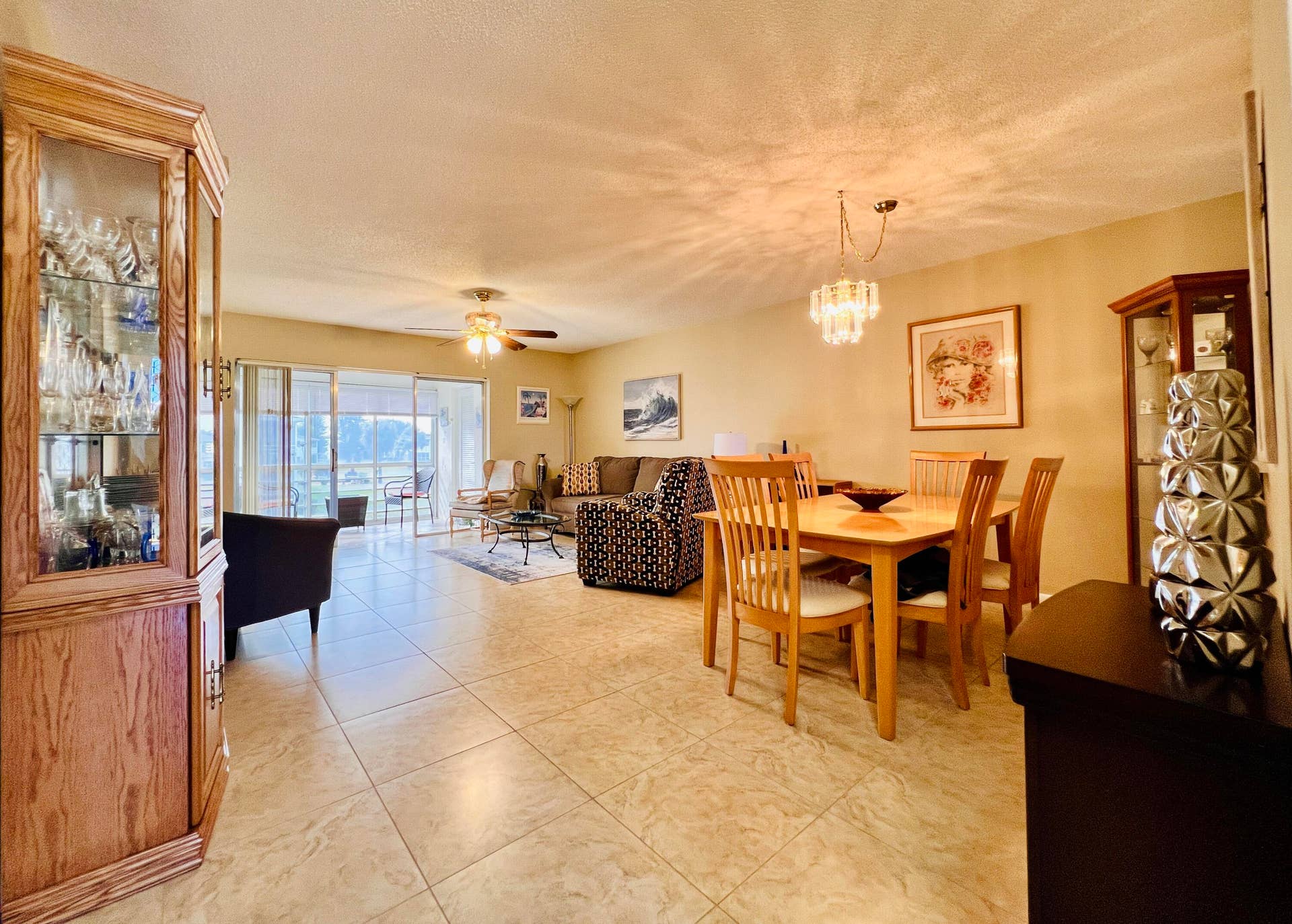 203 Oxford 500, West Palm Beach, FL 33417 Large Living/Dining Area With Neutral Tile Flooring and Access to the Lanai. Sold Furnished As Shown (Fireplace Excluded)