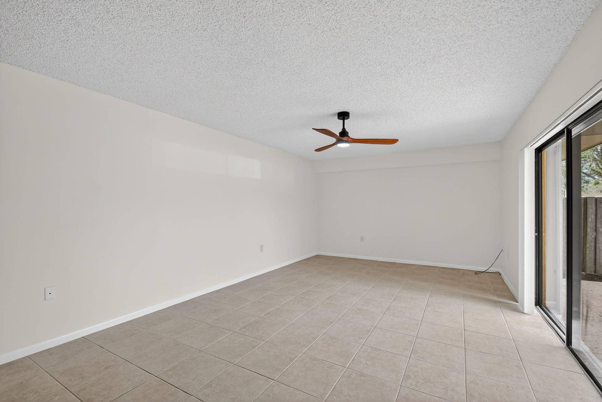 4210 42nd Way, West Palm Beach, FL 33407 Light and bright living area has sliding glass doors that open to the private and fenced patio
