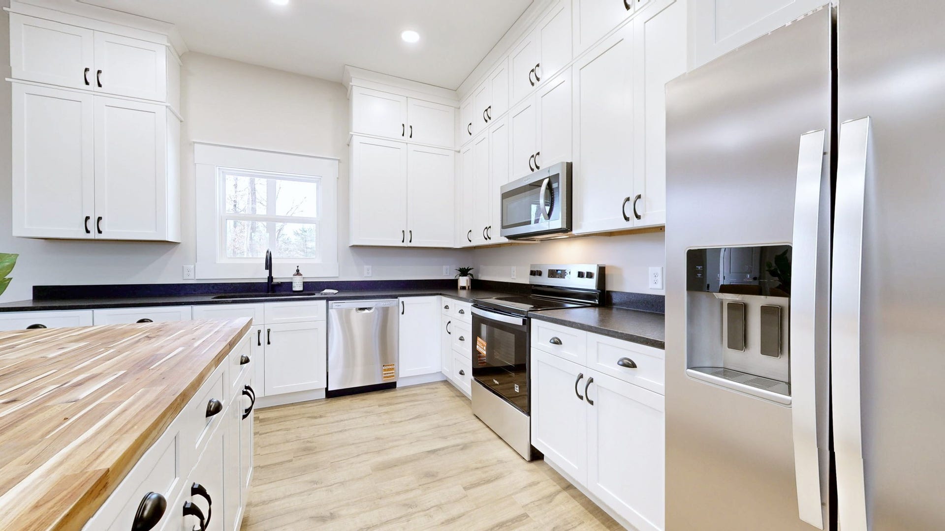 579 Lower Halls Mill Rd, Shelbyville, TN 37160 The kitchen features lots of cabinetry, with granite tops on the base cabinets and a solid wood butcher block top on the island.