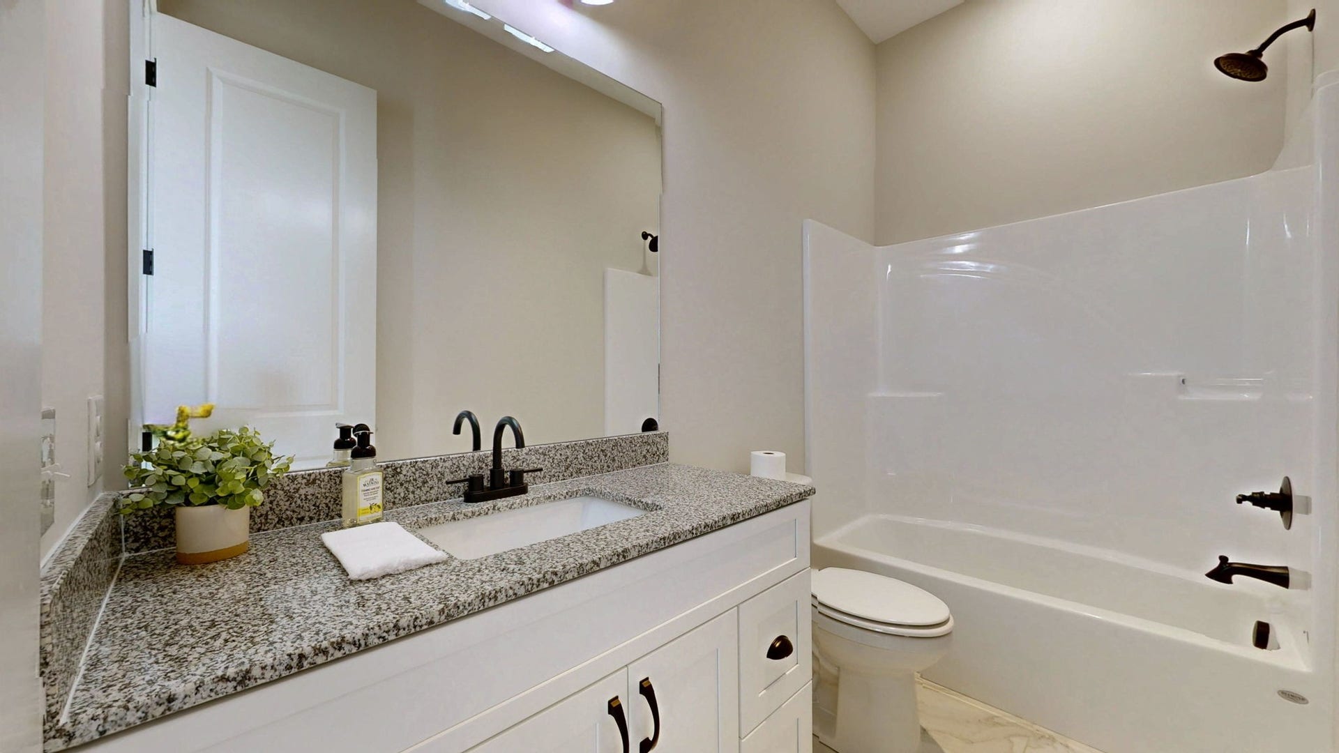 579 Lower Halls Mill Rd, Shelbyville, TN 37160 Bathroom adjoining bedroom 3 features a vanity with granite top, tub/shower combo, and tile floor.