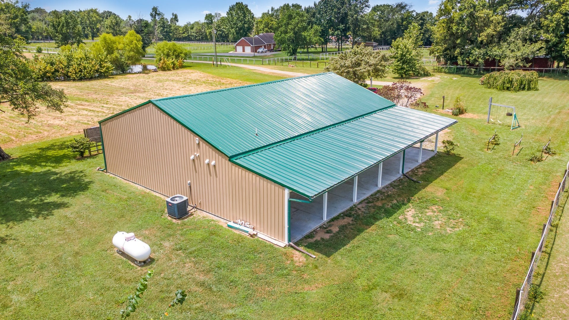 129 Highway 82 East, Bell Buckle, TN 37020 In this photo, we get a look at just how large the home is overall and we also see the blackberry bushes, grape vines, and peach trees off to the right. You can't get much more authentic Tennessee barndominium than this!
